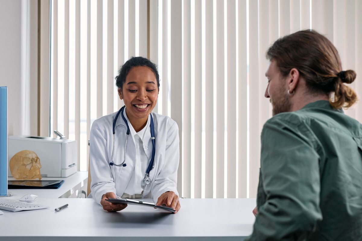 Médica conversando con un paciente en consulta